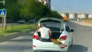 سيارة تسير في تركيا بشخص داخل صندوق الأمتعة وآخر فوق سطحها