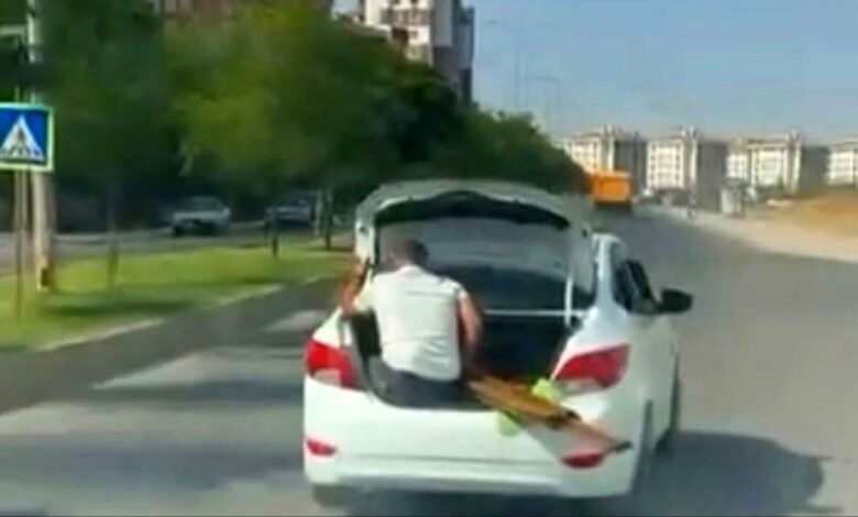 سيارة تسير في تركيا بشخص داخل صندوق الأمتعة وآخر فوق سطحها